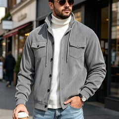 Gray corduroy jacket worn on a city street with coffee in hand