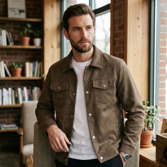 Man wearing brown faux suede trucker jacket in a cozy room with bookshelves