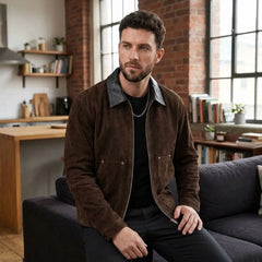 Man in dark brown faux suede zip jacket seated indoors