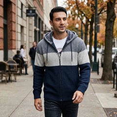 Man in navy knit zip hoodie walking on an autumn city street