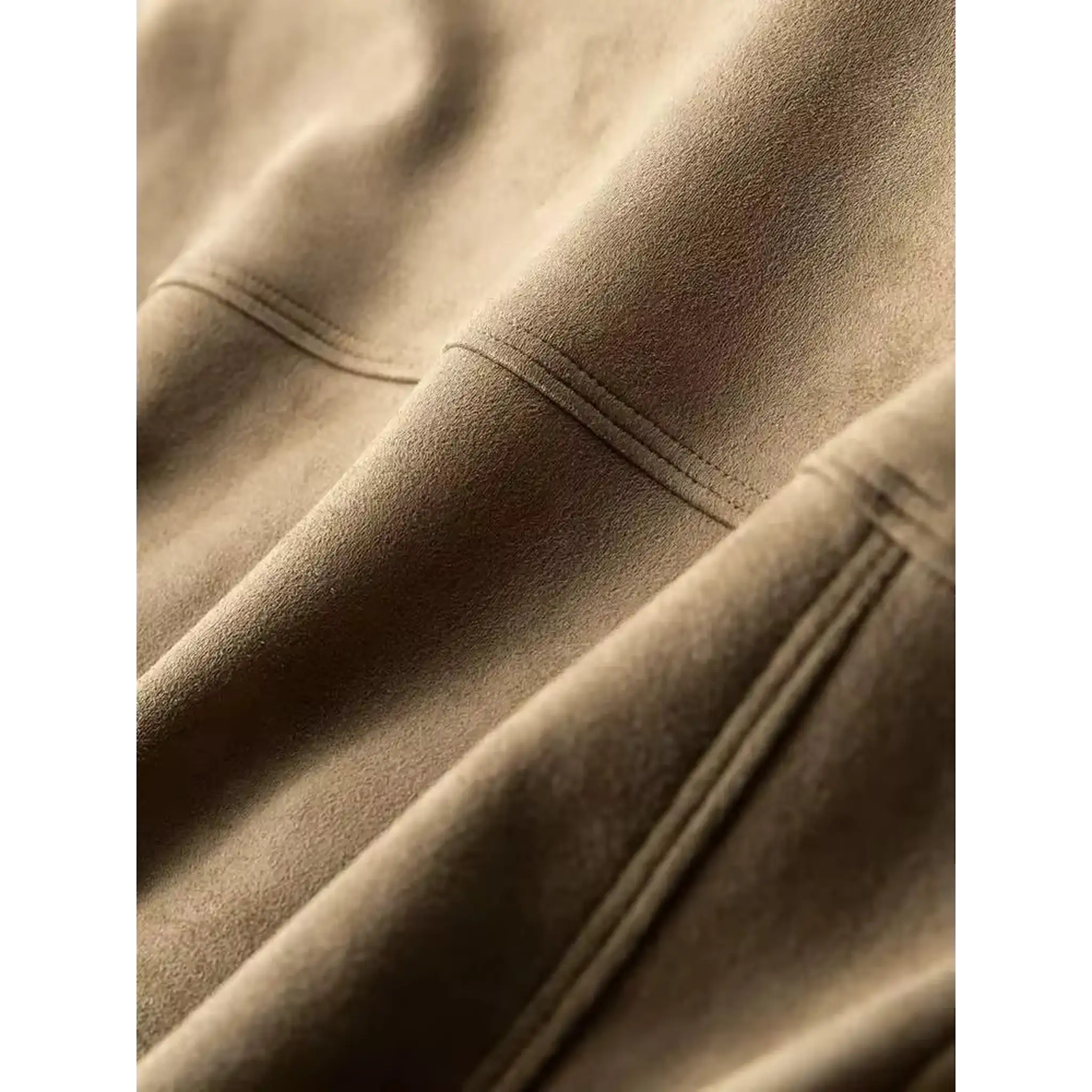 Close-up of the seam stitching and suede-like texture on a khaki trucker jacket