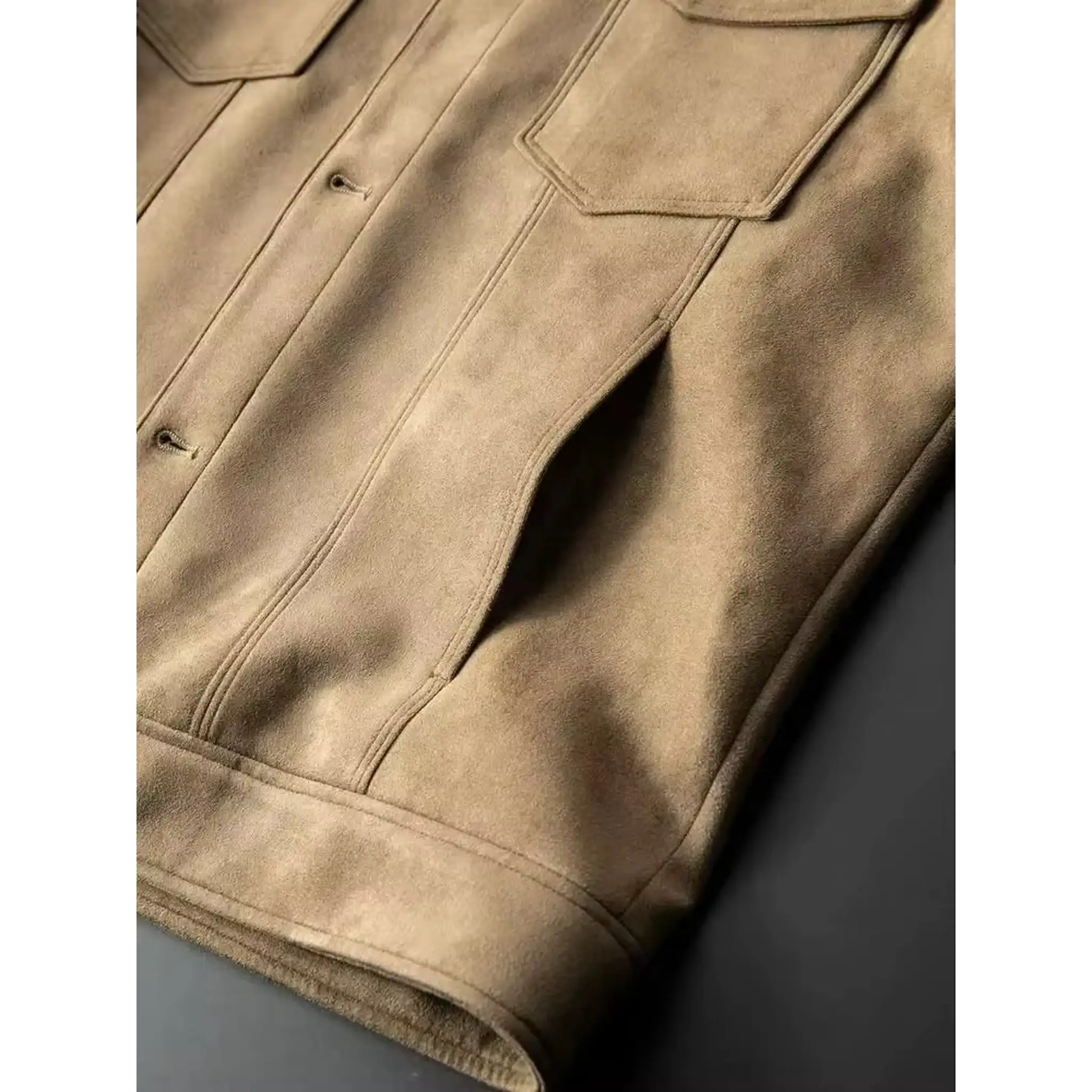 Close-up of the chest flap pockets and lower side pocket on a khaki suede-look trucker jacket