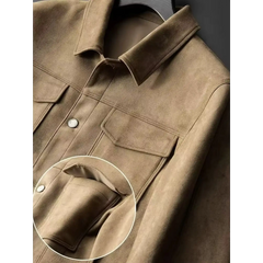 Close-up of the buttoned chest flap pocket on a khaki suede-look trucker jacket