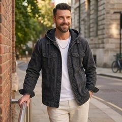 Man in black hooded denim jacket and white tee on a city street