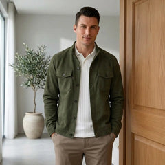 Man in army green suede jacket and white tee in a bright modern interior