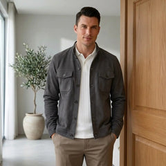 Man in grey suede jacket and white tee in a bright modern interior