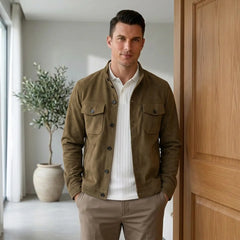 Man in khaki suede jacket and white tee in a bright modern interior