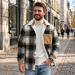 Man in black plaid shirt jacket and turtleneck on a city street