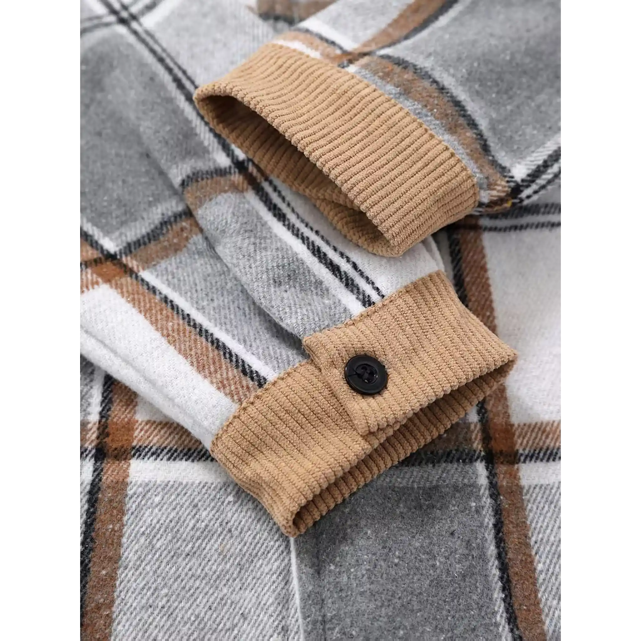 Close-up of corduroy cuff and snap button on light grey plaid shirt jacket