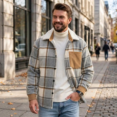 Man in light grey plaid shirt jacket and turtleneck on a city street