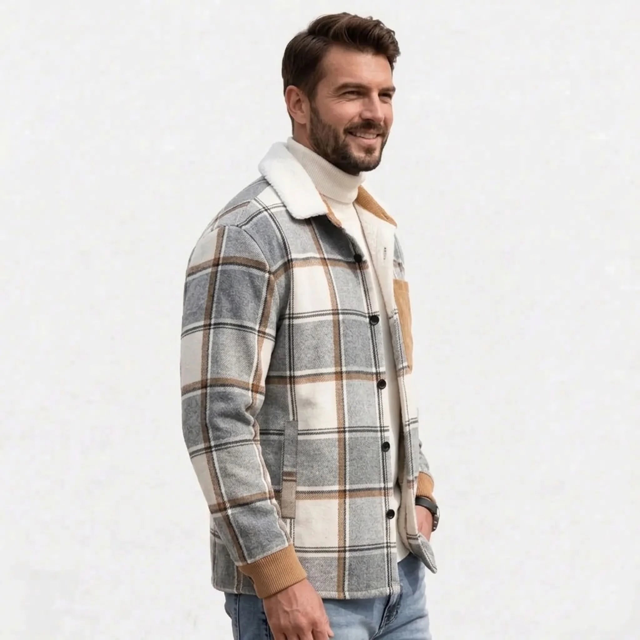 Man wearing light grey plaid shirt jacket over cream turtleneck, side view