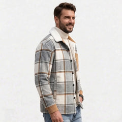 Man wearing light grey plaid shirt jacket over cream turtleneck, side view