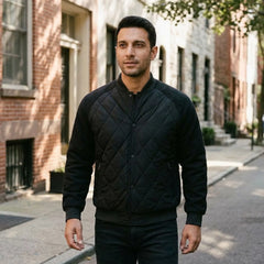 Man wearing black quilted bomber jacket on a city street