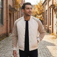 Man wearing cream two-tone quilted bomber jacket on an autumn street