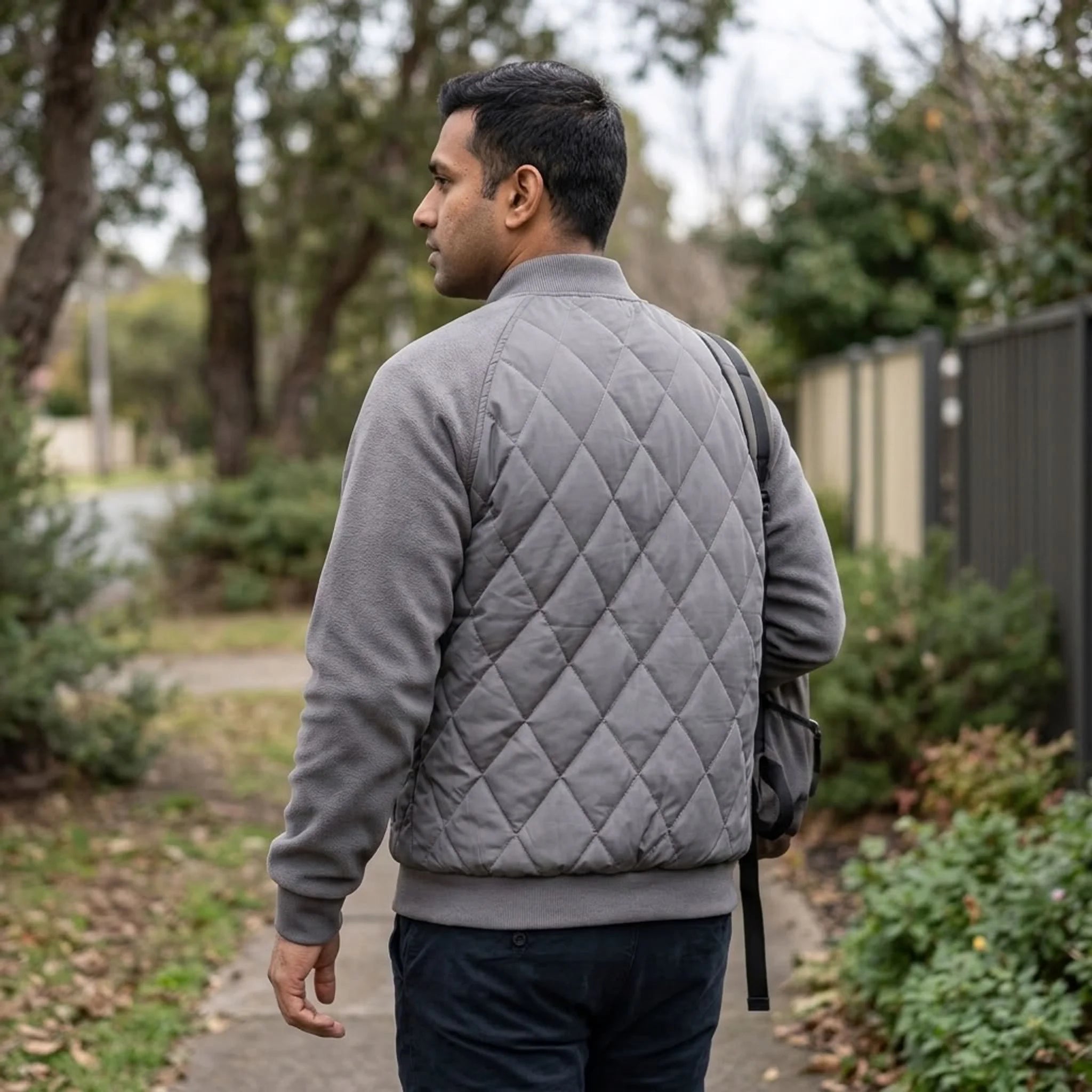 Grey quilted bomber jacket on an autumn street, back view