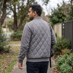 Grey quilted bomber jacket on an autumn street, back view