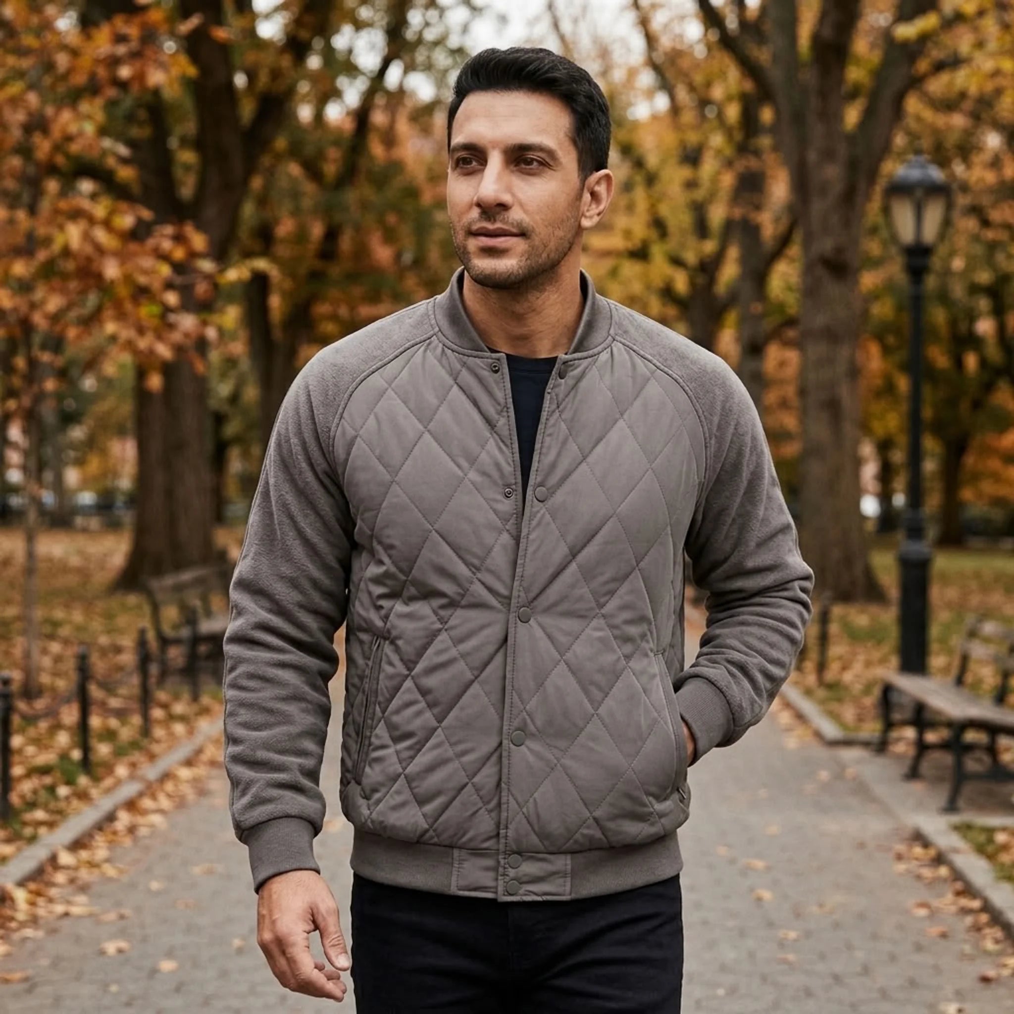 Man wearing grey quilted bomber jacket on an autumn street