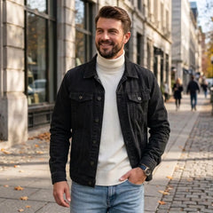Man wearing black denim jacket with white turtleneck on a city street