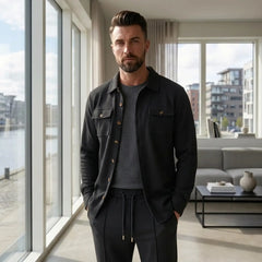 Black waffle knit set worn open over a grey tee in a modern apartment