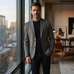 Grey wool blend blazer worn by a window in a city apartment