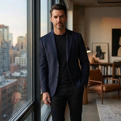 Navy wool blend blazer worn by a window in a city apartment