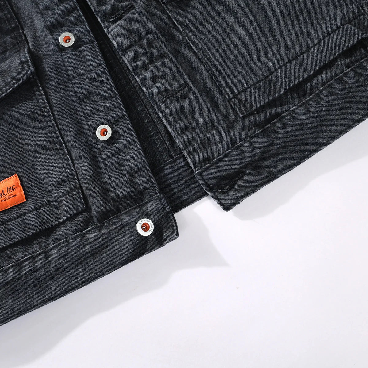 Washed black denim jacket patch pocket and button detail