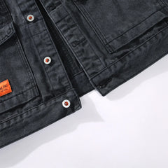 Washed black denim jacket patch pocket and button detail