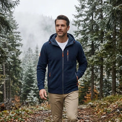 MannerCo navy blue fleece hoodie worn walking through a misty pine forest