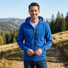 MannerCo royal blue fleece hoodie worn on a sunny hillside trail