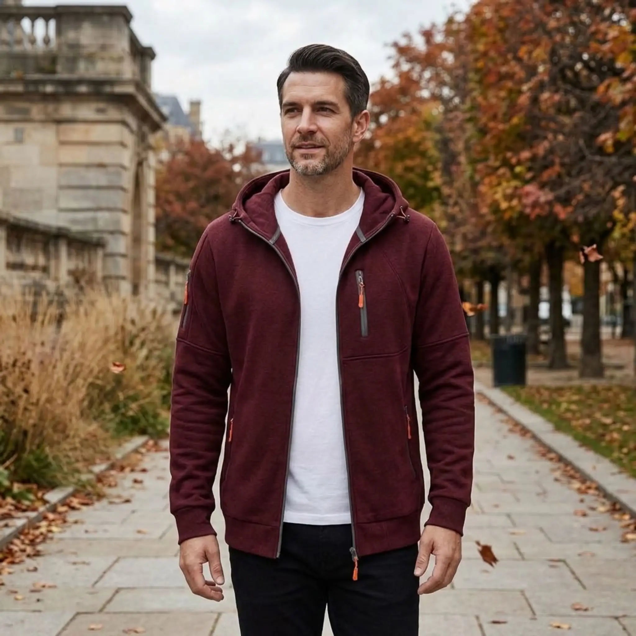 MannerCo wine red fleece hoodie worn open over white tee on a city promenade