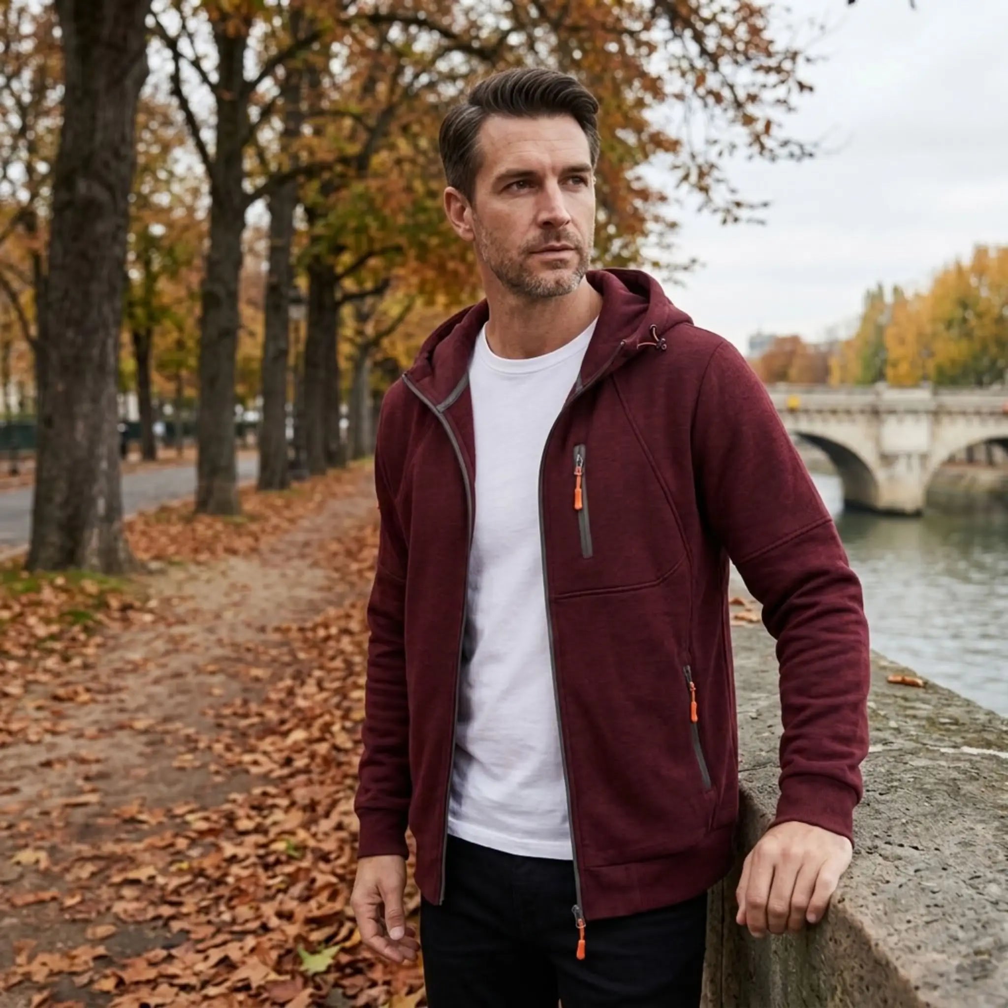 MannerCo wine red fleece hoodie worn on an autumn riverside path