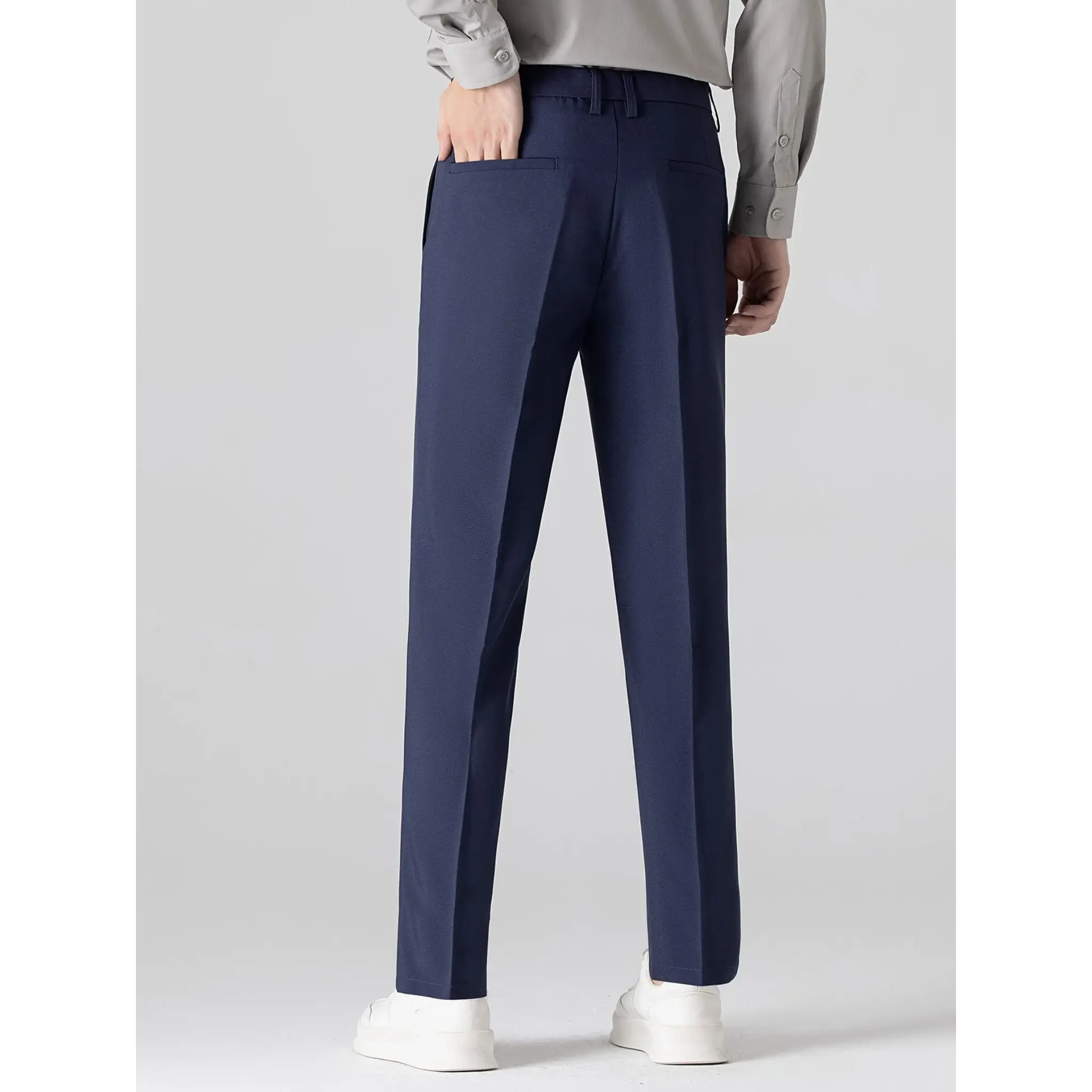 MannerCo navy slim fit tapered trousers back view with white sneakers