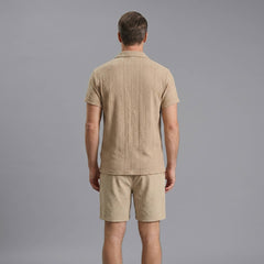 Back view of man wearing navy geometric jacquard button up shirt and crinkle textured shorts