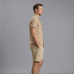 Side view of man in navy geometric jacquard button up shirt and crinkle textured shorts