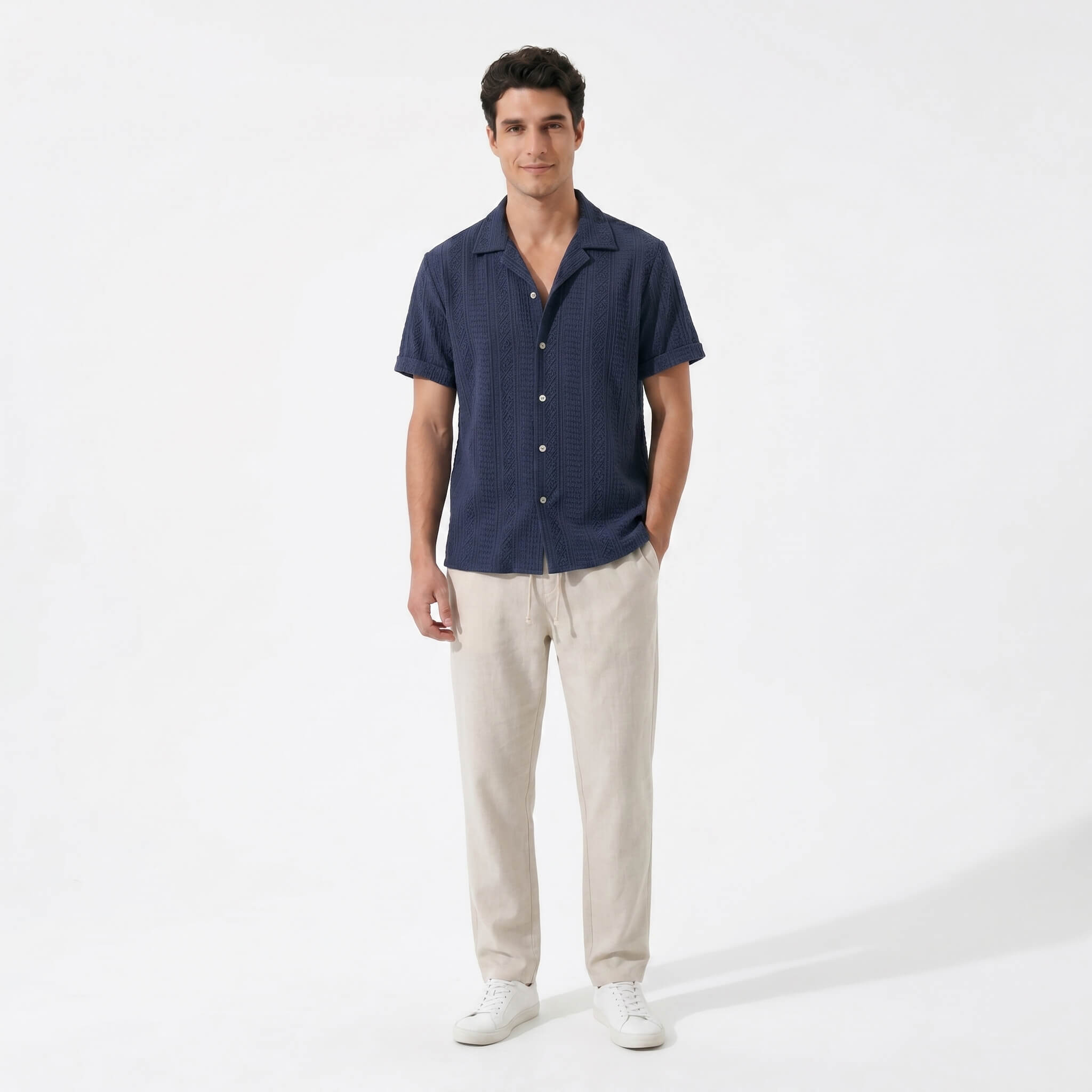 Man wearing a navy geometric jacquard button up shirt and straight leg linen pants front view on white background