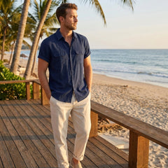 Man in navy linen rayon blend utility shirt and linen pants walking in sunny outdoor summer scene