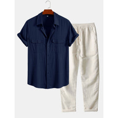 Navy shirt and beige pants on a hanger against a white background