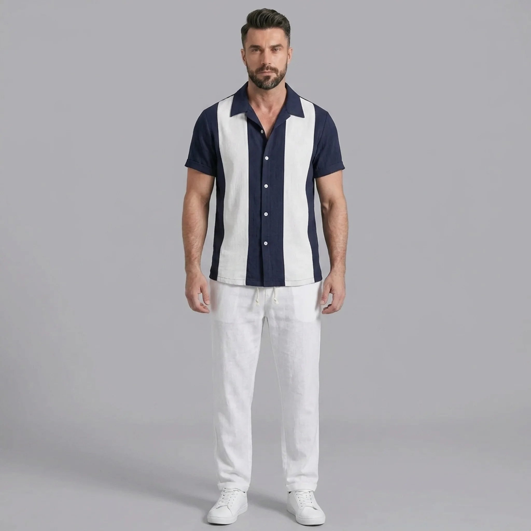 Man wearing a navy patchwork cotton bowling shirt and straight leg linen pants front view on plain background