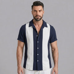 Man wearing navy patchwork bowling shirt and linen pants in outdoor lifestyle setting