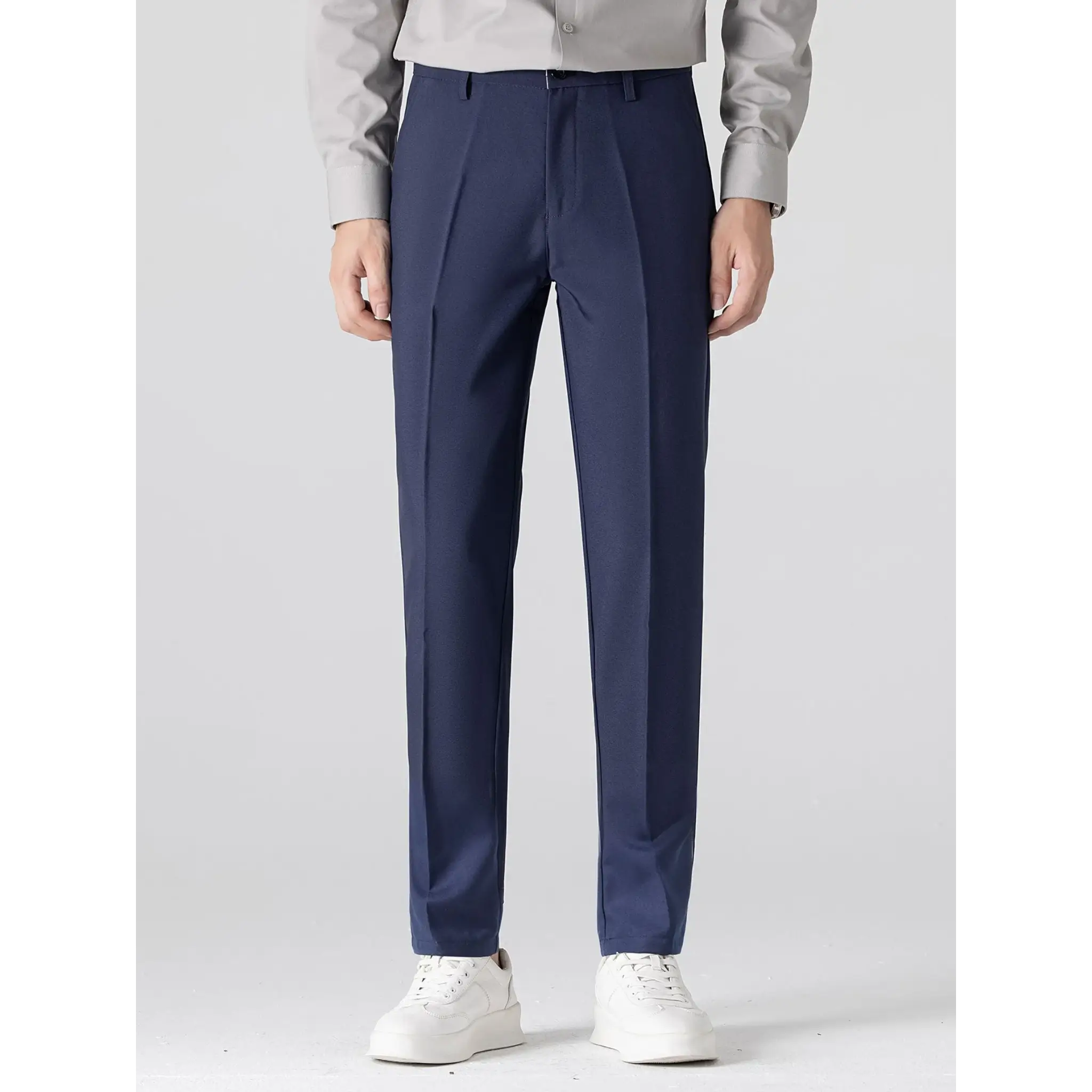MannerCo navy slim fit tapered trousers front view with white sneakers