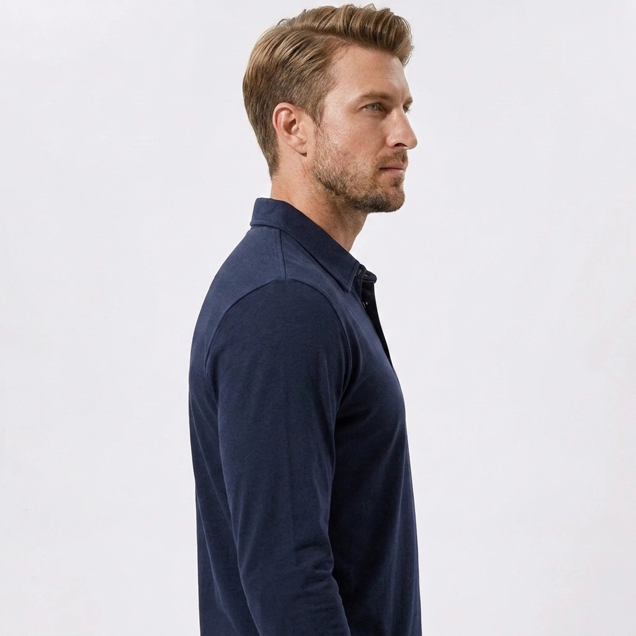 Side view of man in navy solid long sleeve cotton polo shirt on plain background