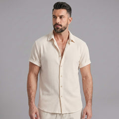 Man wearing navy waffle button up shirt and linen pants walking outdoors