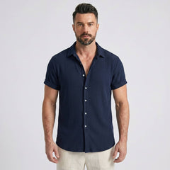 Back view of man wearing navy waffle button up shirt and straight leg linen pants