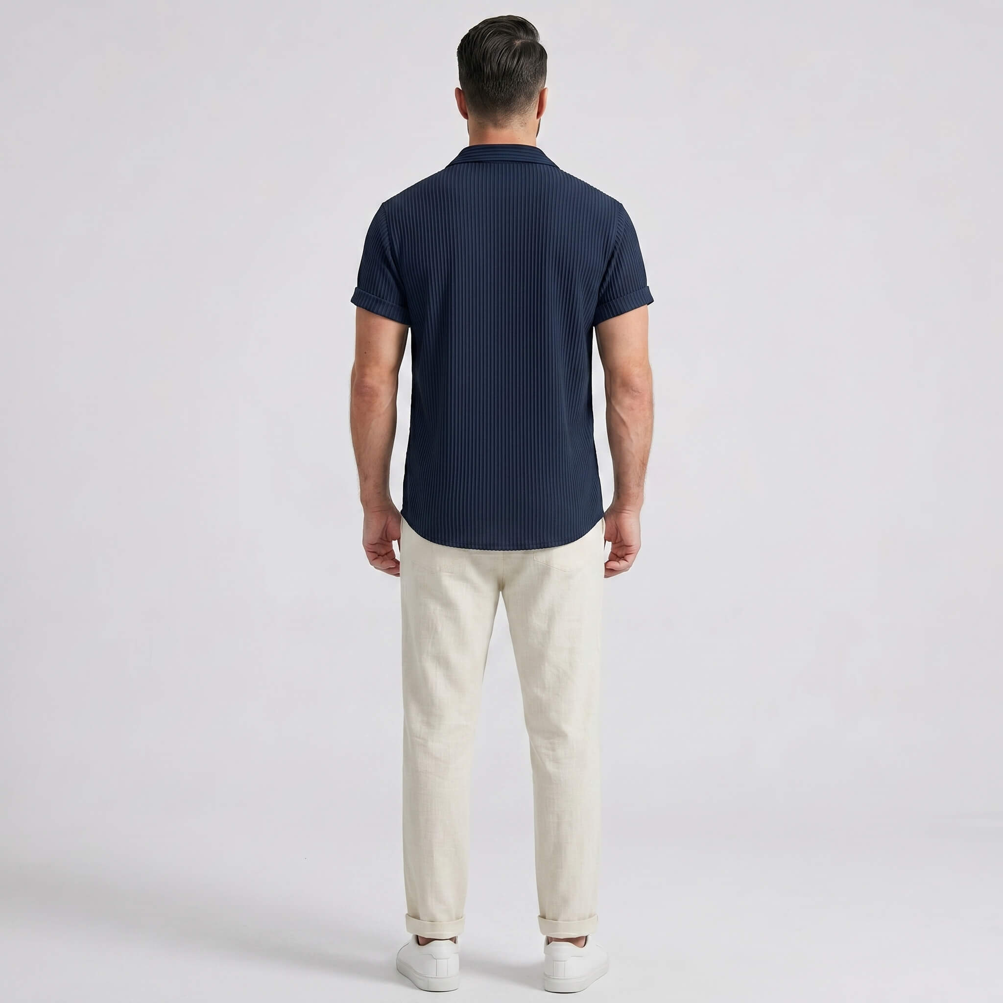 Side view of man in navy waffle button up shirt and straight leg linen pants