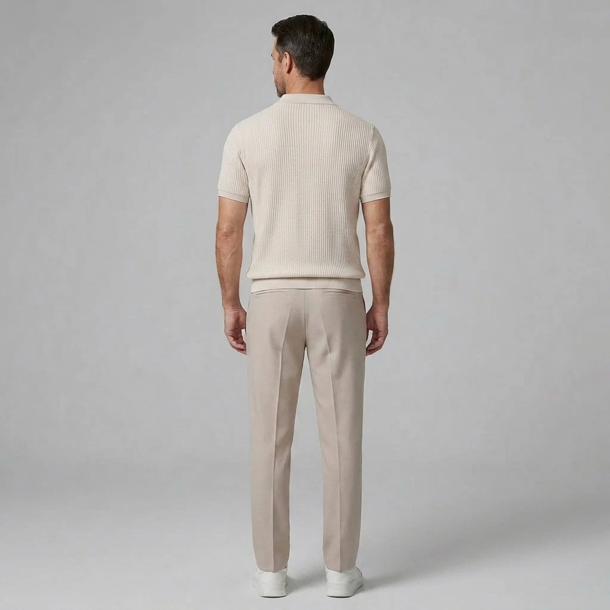 Man wearing a navy waffle johnny collar polo shirt and slim fit tapered pants front view
