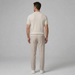 Man wearing a navy waffle johnny collar polo shirt and slim fit tapered pants front view