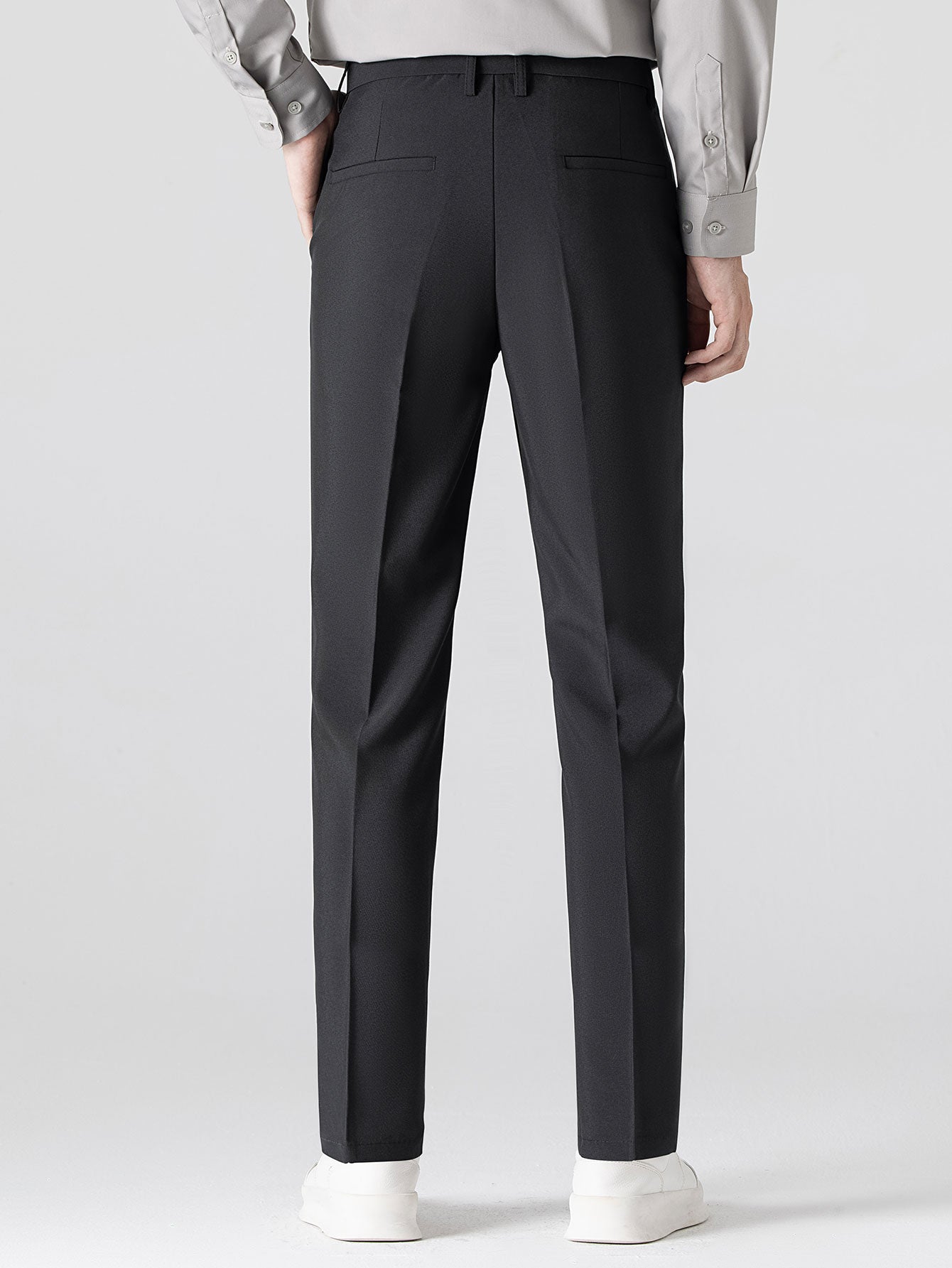 Man in navy waffle polo and tapered pants three quarter view on plain background