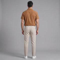 Back view of man wearing orange linen Cuban collar shirt and slim fit tapered trousers
