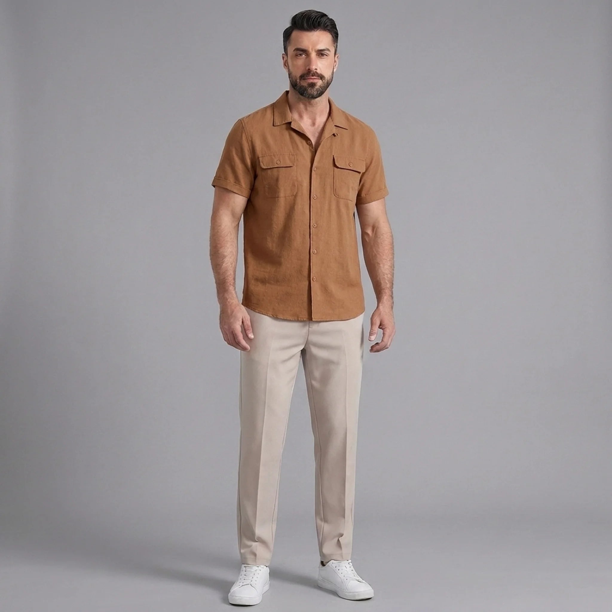 Man wearing an orange linen Cuban collar shirt and slim fit tapered trousers front view on plain background