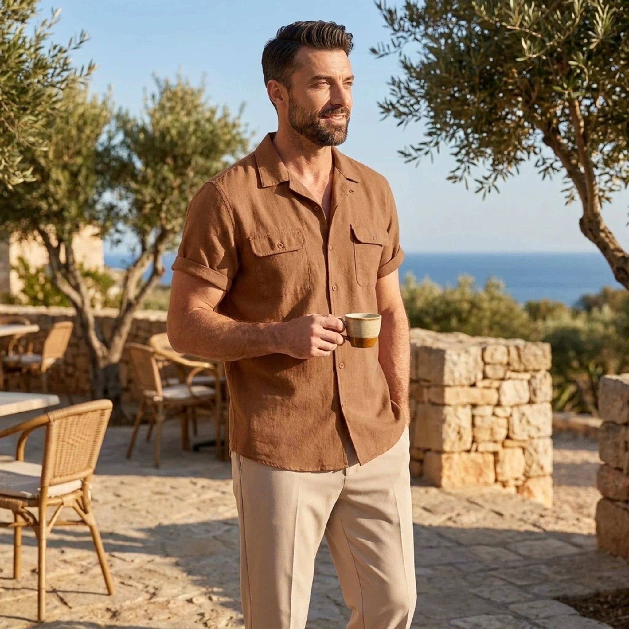 Man wearing orange linen Cuban collar shirt and slim fit tapered trousers in outdoor lifestyle setting